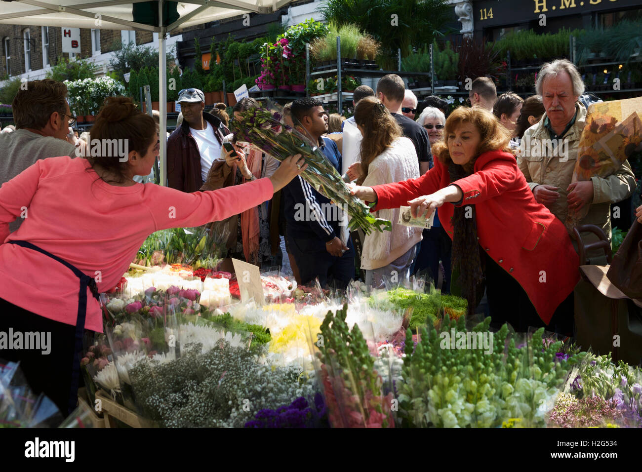 Columbia Road Flower Market, Londra, Inghilterra, Regno Unito. Commerciante di strada che vendono fiori, il cliente il pagamento in contanti. Commerciante indipendente. Foto Stock