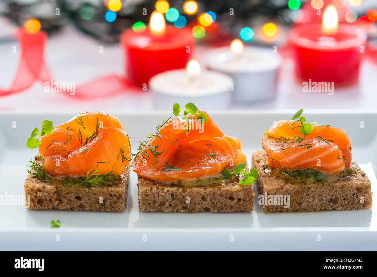 Deliziosi antipasti crostini di pane nero con salmone affumicato per le vacanze Foto Stock