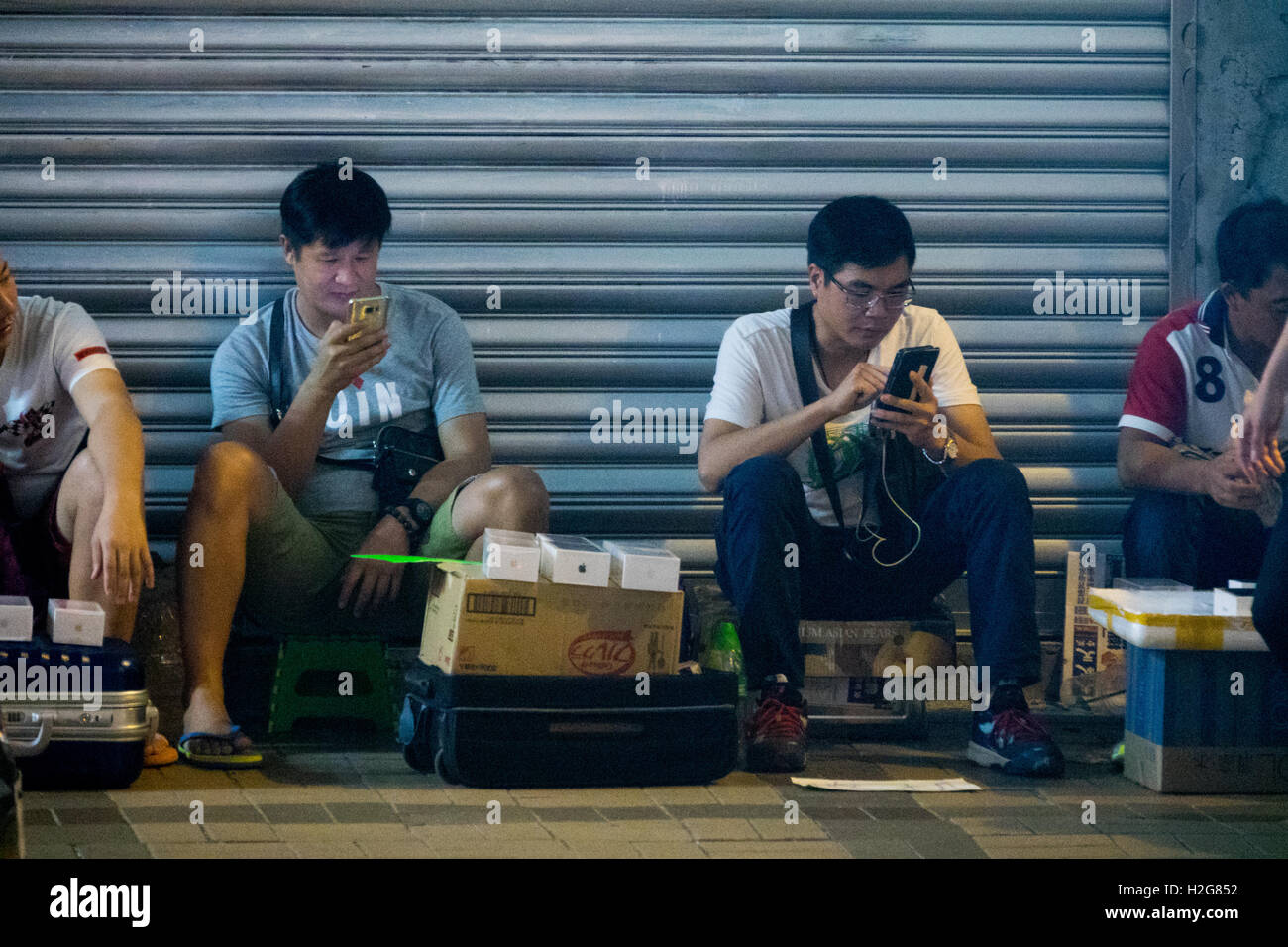 Scalpers vendere il nuovo iPhone 7s al di fuori dell'Apple Store su Canton Road di Hong Kong ad acquirenti benestanti che non vogliono attendere Foto Stock