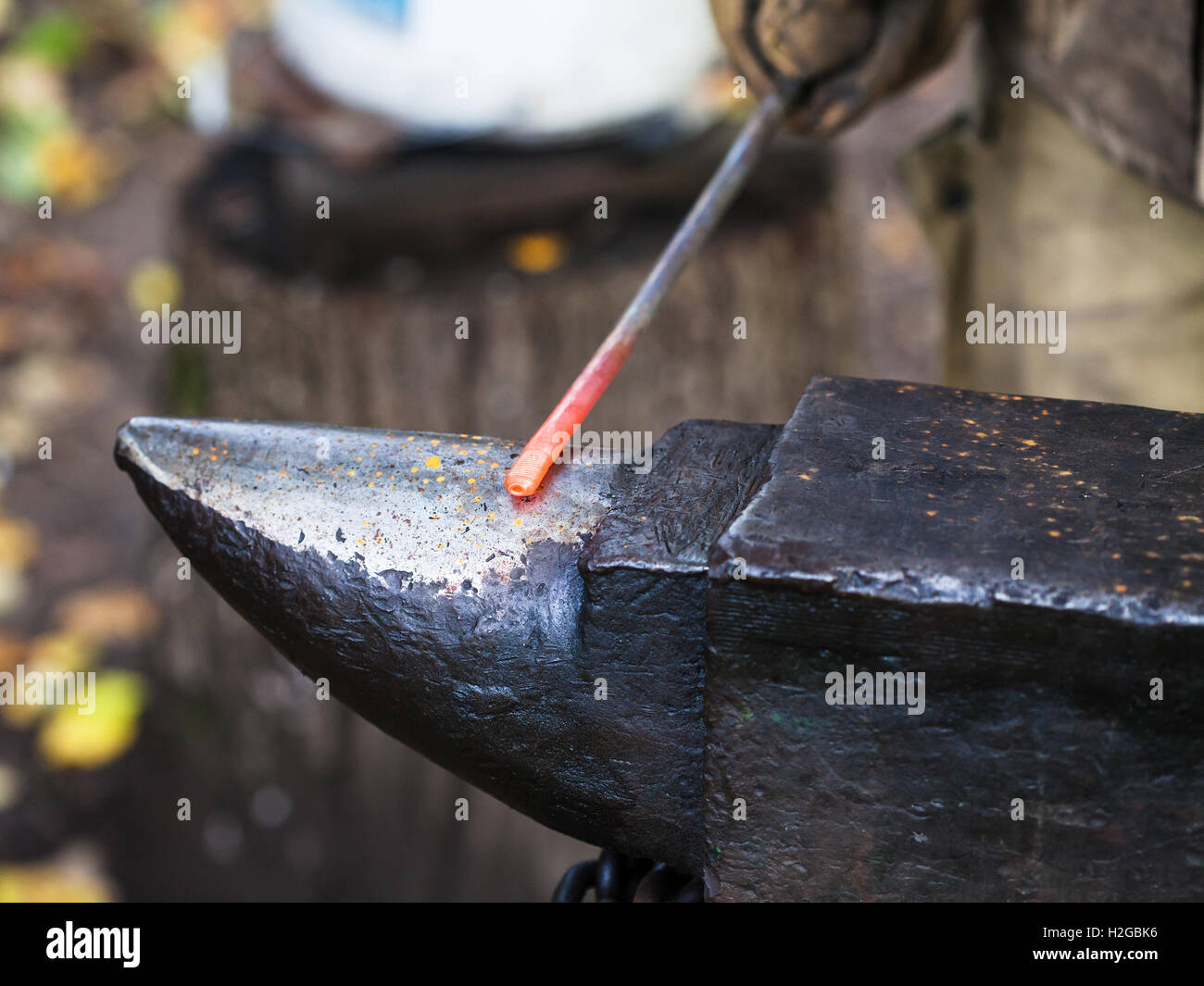 Red Hot tondino di ferro sull'incudine in outdoor fucina rurale Foto Stock