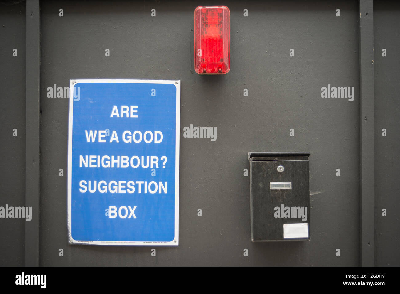 Siamo un buon vicino di casa? Scatola di suggerimenti su una parete di un edificio sito a Londra Foto Stock