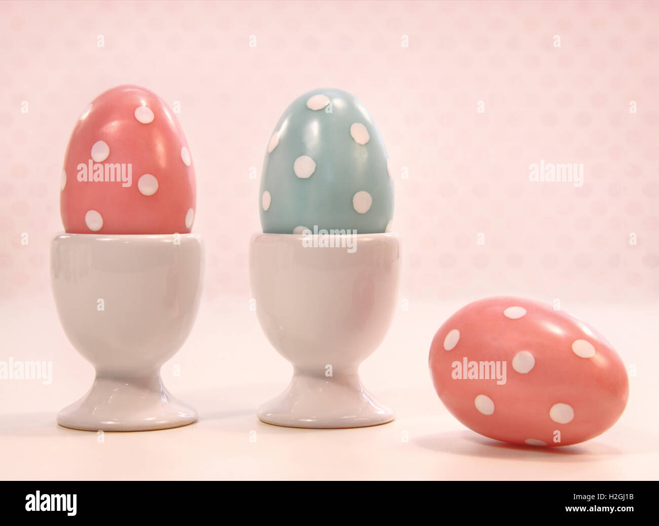 Uova colorate in bianco tazze Foto Stock