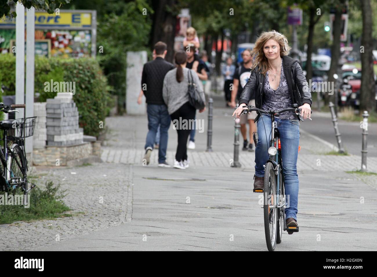 Donna bionda rigidi senza casco sul Bürgersteig bicicletta. 15.08.2016 | Utilizzo di tutto il mondo Foto Stock