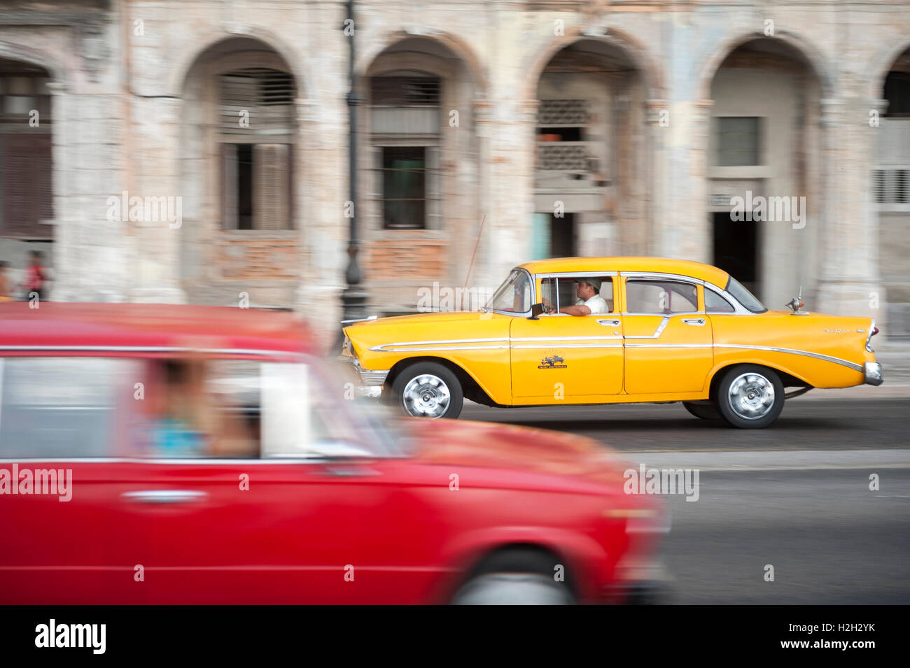 L'Avana - Giugno 13, 2011: vivacemente colorato vintage americano auto taxi condividono la strada in motion blur sul lungomare Malecon. Foto Stock