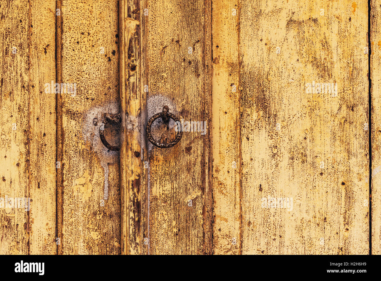Weathered porta in legno con metallo arrugginito battenti, texture dettagliate della vecchia, ruvido legno Foto Stock