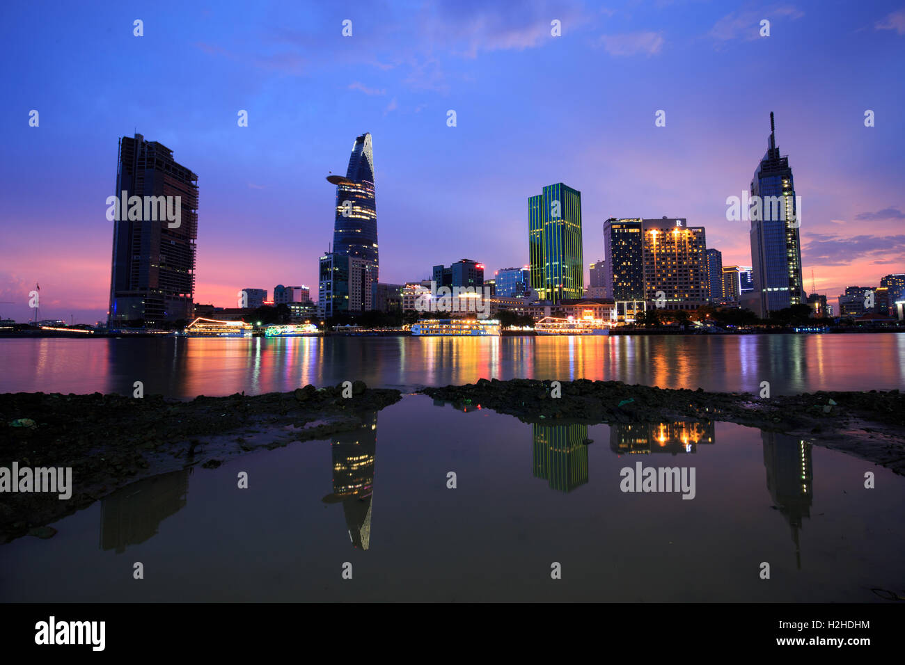 Sunset riverside lungo bellissimi grattacieli scintillanti del carbone più luminoso mostra lo sviluppo in città di Ho Chi Minh Foto Stock