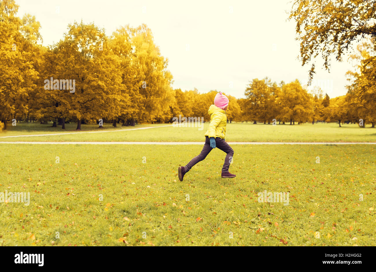 Felice bambina in esecuzione in autunno park Foto Stock