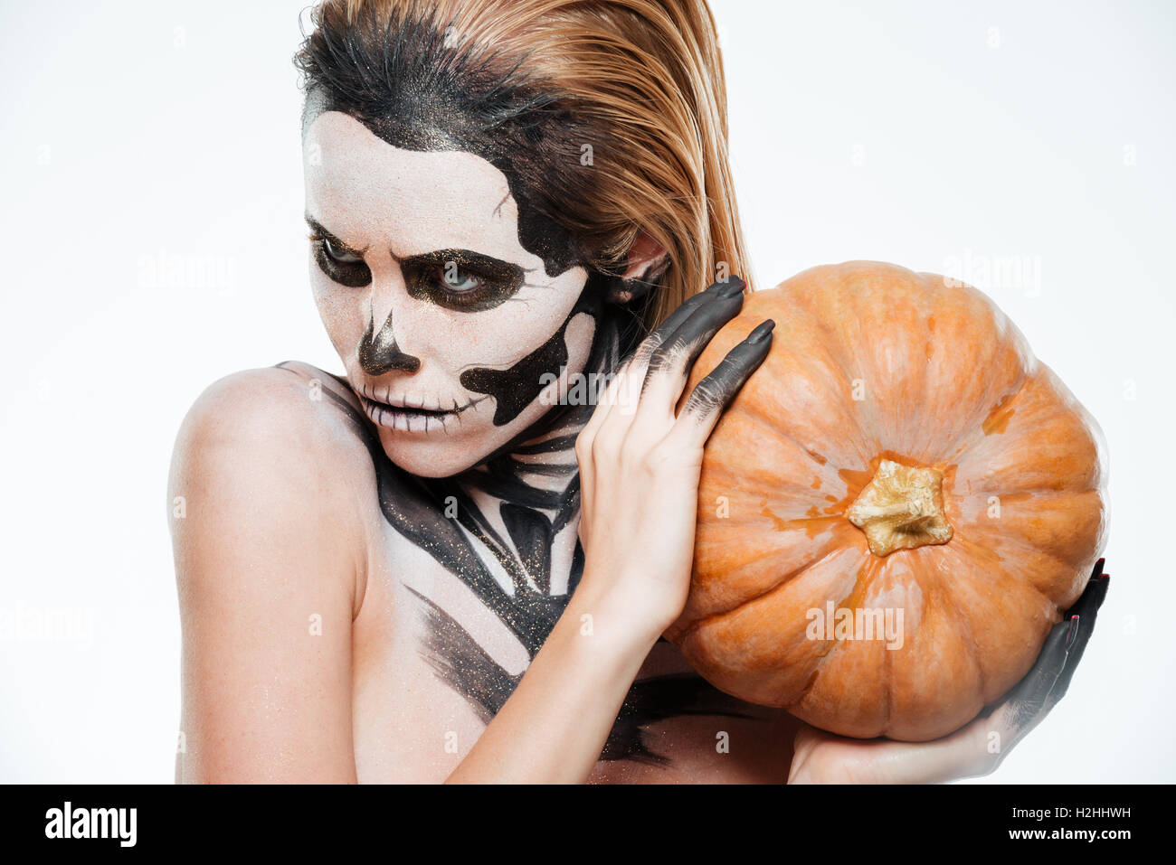 Ritratto di ragazza con paurosi Halloween trucco tenendo la zucca su sfondo bianco Foto Stock
