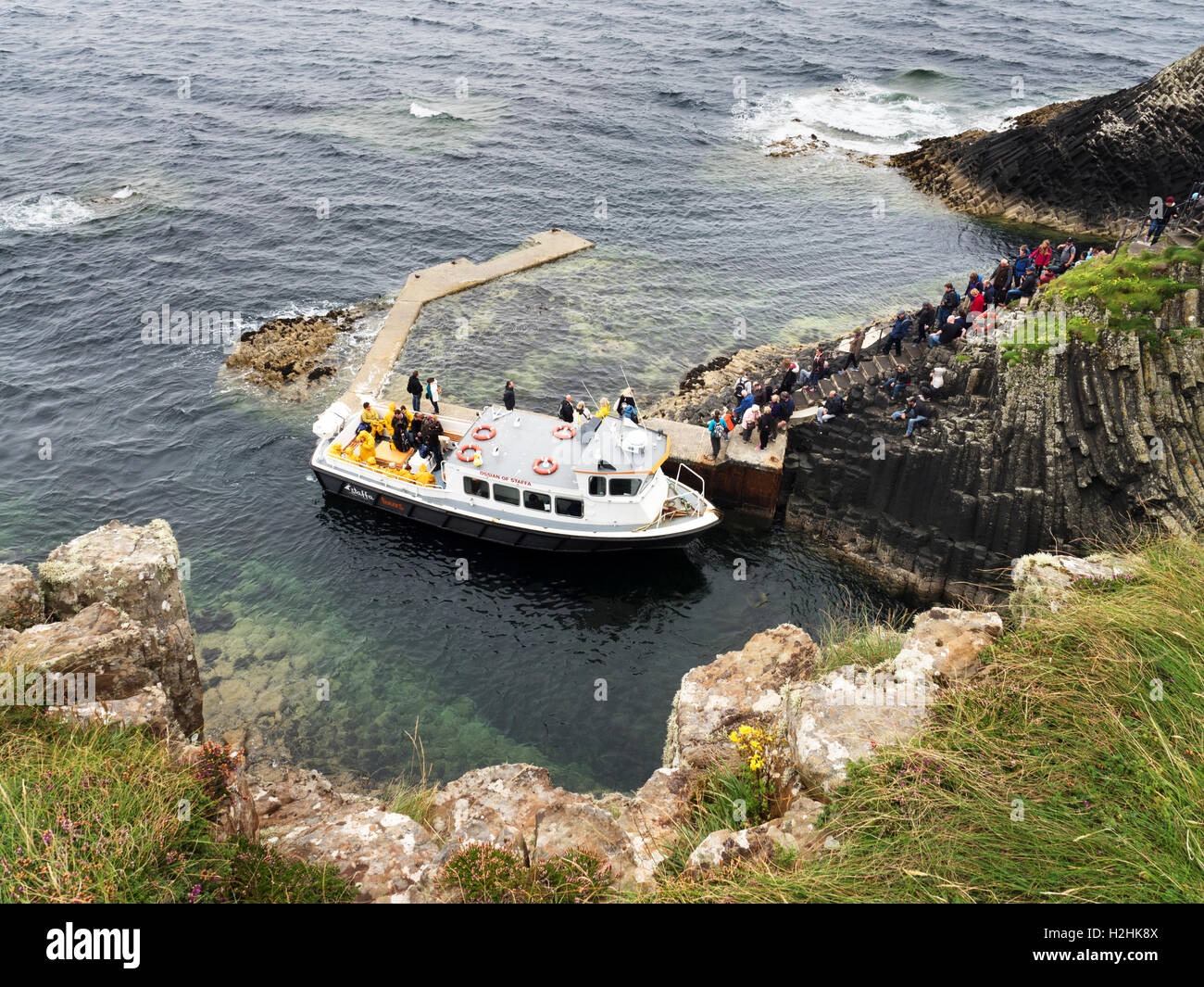 La gente di discesa delle fasi di scogliera e salire a bordo di una barca al pontile sulla staffa Argyll and Bute Scozia Scotland Foto Stock