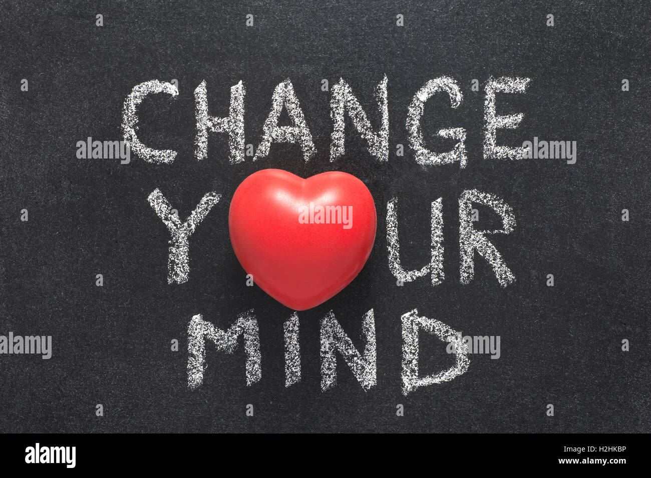 Cambia la tua mente una frase scritta a mano sulla lavagna con il simbolo del cuore di invece di o Foto Stock