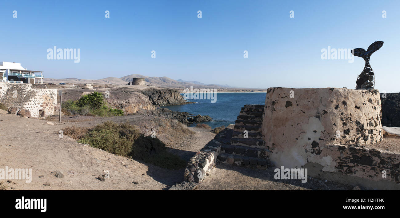 Fuerteventura Isole Canarie, Nord Africa, Spagna: vista panoramica di El Tostón castello e un pubblico di coda di balena scultura nel villaggio di El Cotillo Foto Stock