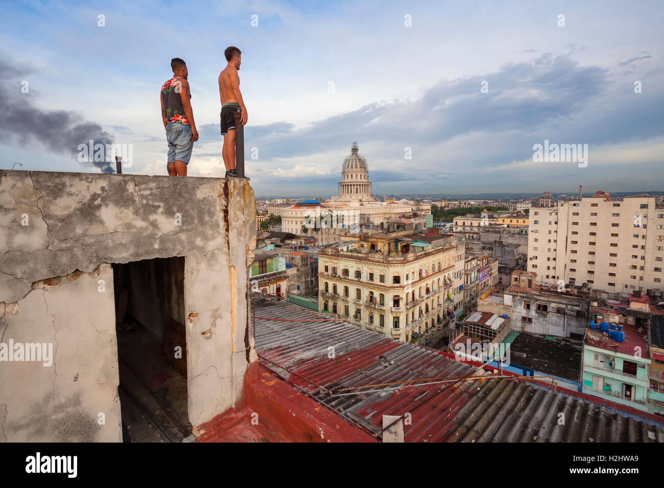 Due uomini ammirando la vista da un tetto con Capitolio visibile in distanza nel centro di Avana, Cuba. Foto Stock