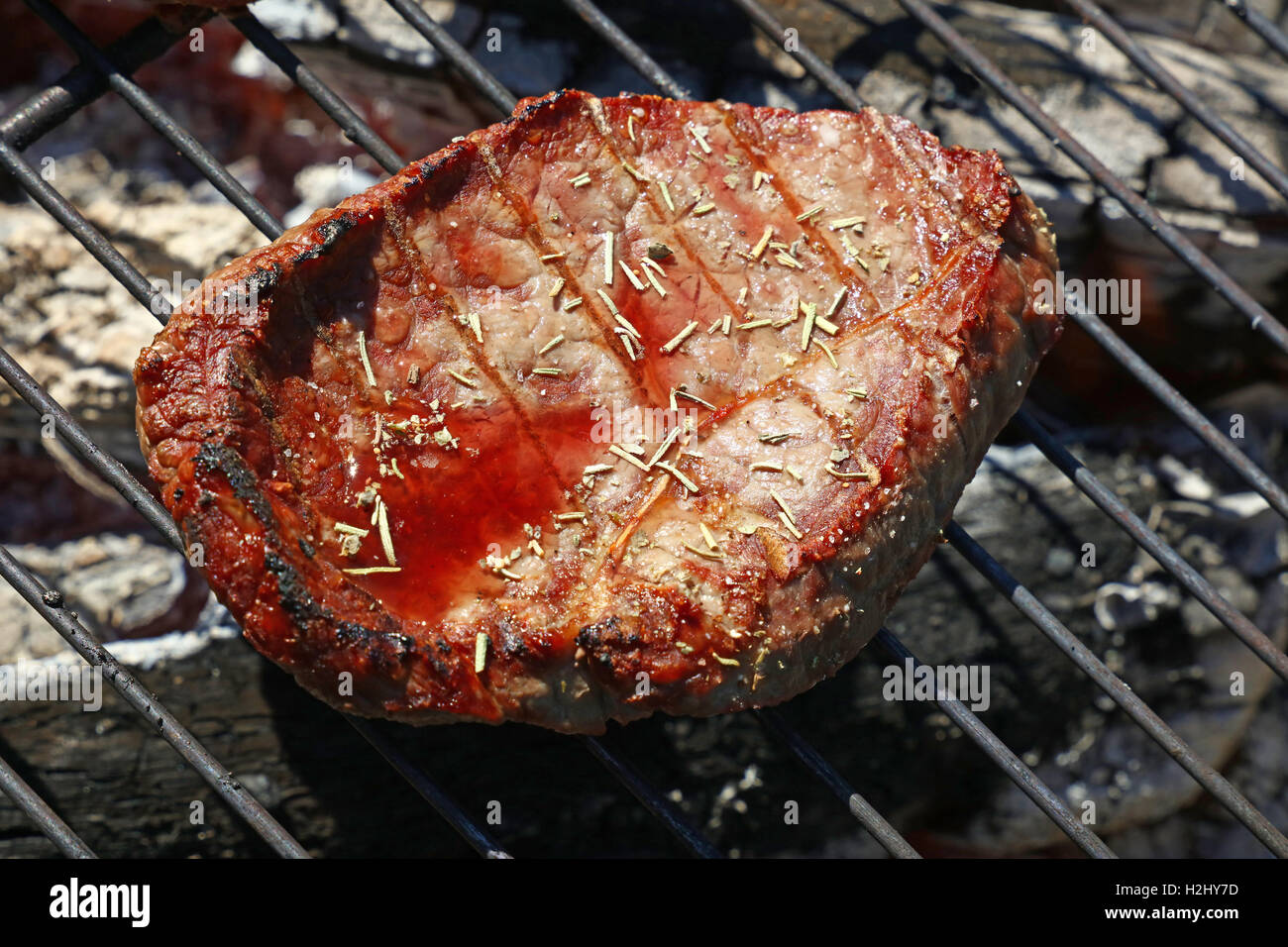 Una rara cotte alla brace barbecue carne di manzo con spezie e sangue succo di carne preparati per la cottura sulla griglia per il barbecue, close up Foto Stock