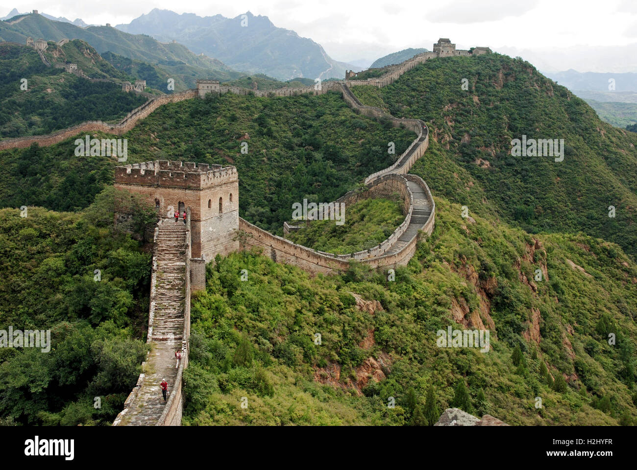 Camminando sulla Grande Muraglia della Cina a Jinshanling. La parete serpenti oltre le montagne come lo rende il modo di Simotai. Foto Stock