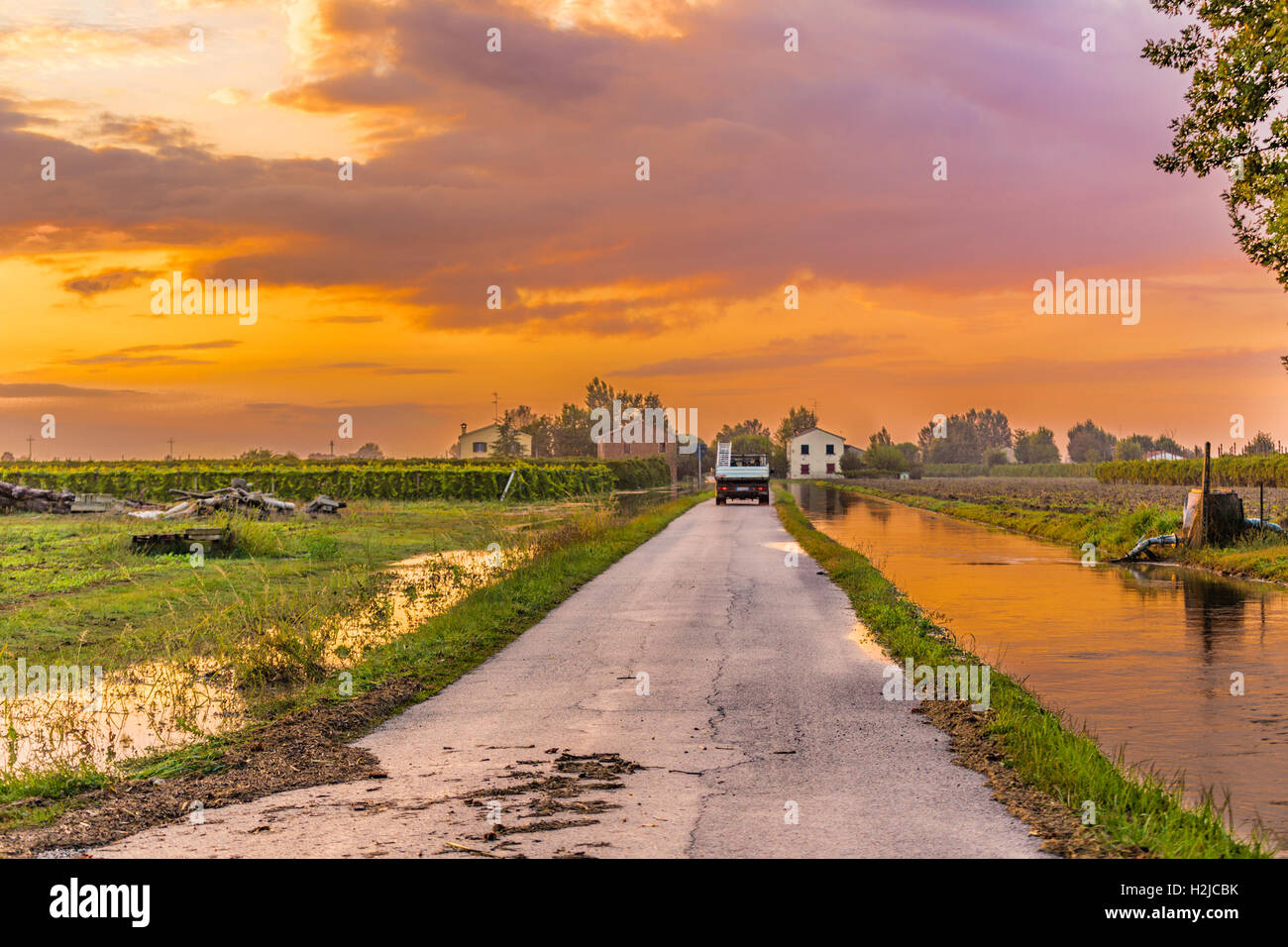 Via sulla strada sterrata vicino al canale di irrigazione in campagna italiana Foto Stock