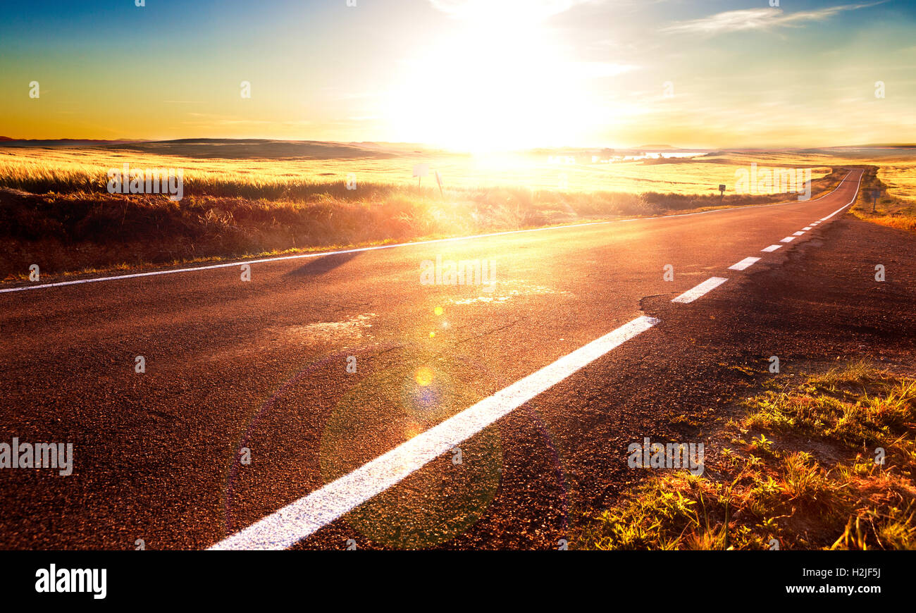 Avventure e i viaggi su strada.la luce del sole e la strada linee.Road e campi Foto Stock