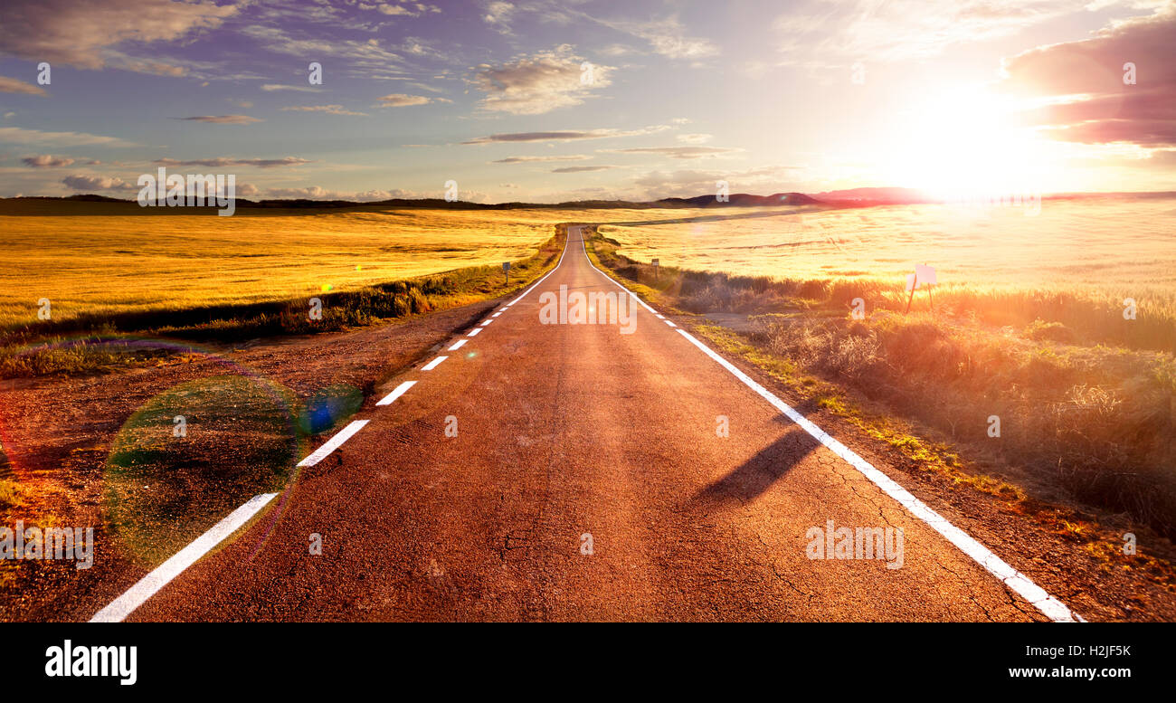 Avventure e i viaggi su strada.il tramonto e il concetto di viaggio.Road e campi Foto Stock