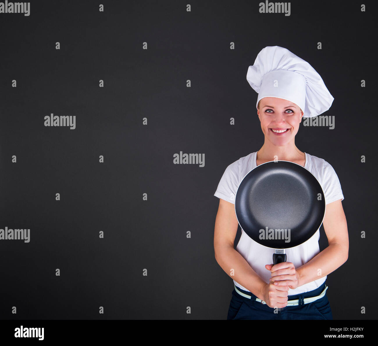La cottura di cibo e di concetto - femmina sorridente chef cuoco o baker con pan Foto Stock