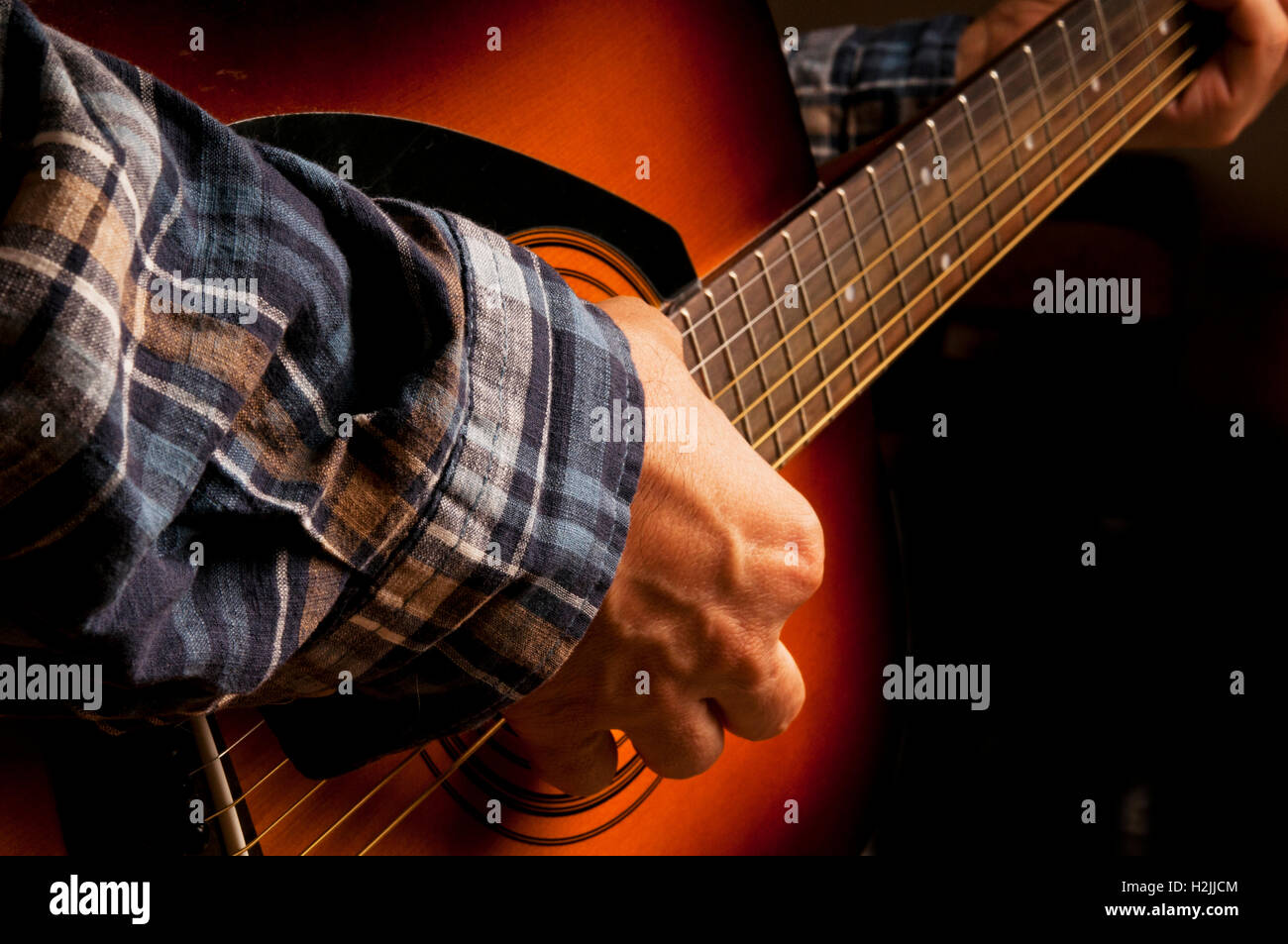 Maschio chitarrista suonando una chitarra acustica Foto Stock