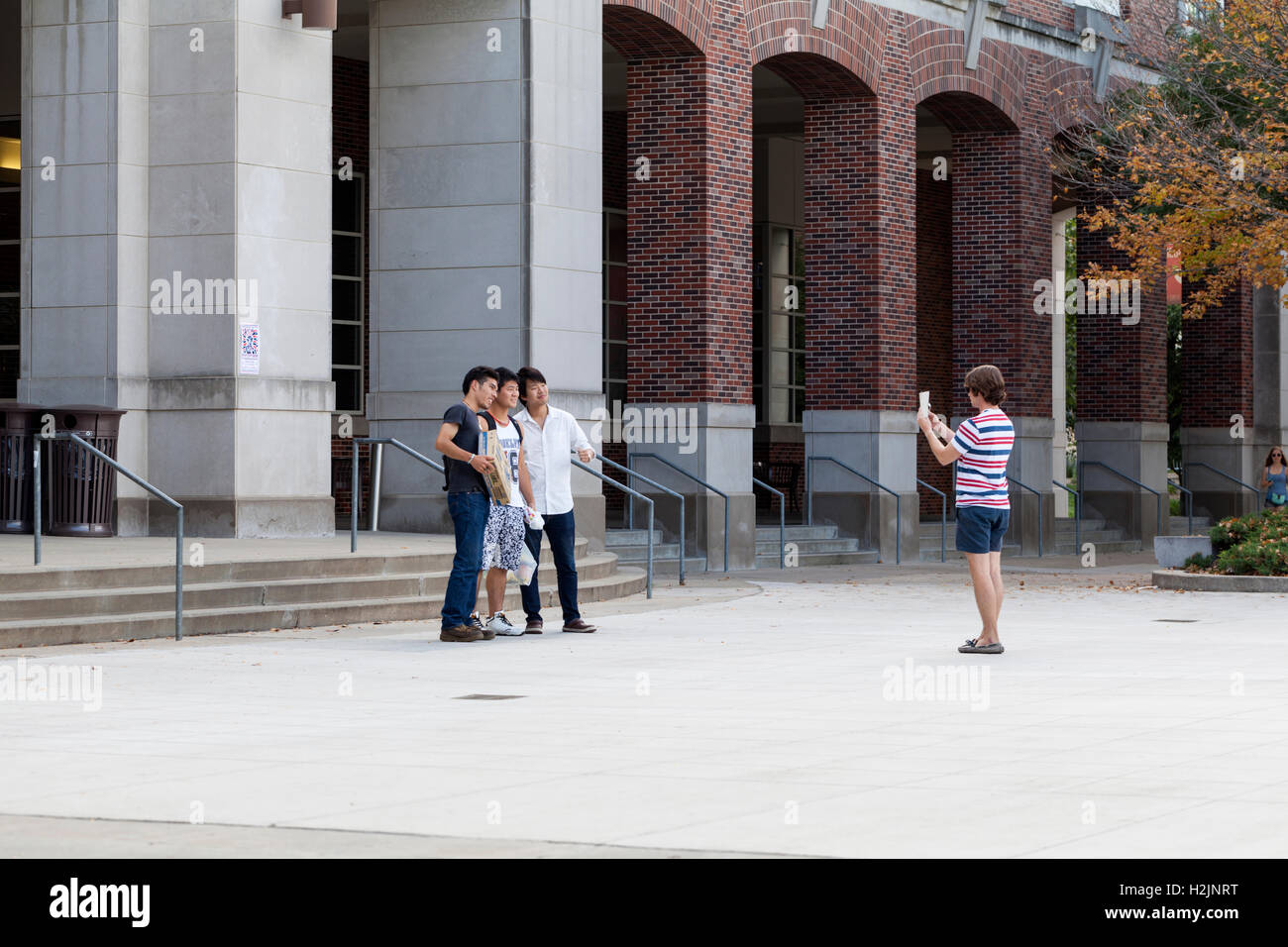 Una persona che prende un'immagine con un telefono cellulare di un gruppo. Foto Stock