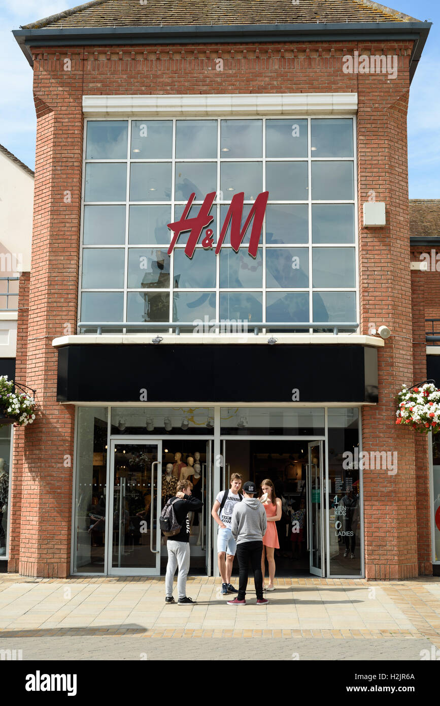 La vetrina di H&M in Colchester con persone che entrano nella grande catena di fashion store in Essex, Inghilterra Foto Stock La vetrina di H&M in Colchester con persone che entrano nella grande catena di fashion store in Essex, Inghilterra Foto Stock