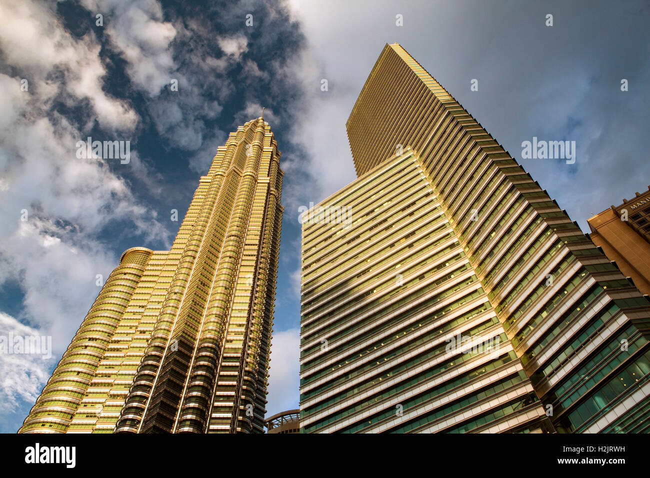 Petronas Tower 2 e edifici adiacenti guardare come essi sono realizzati in oro nel tardo pomeriggio di sole di impostazione. Foto Stock