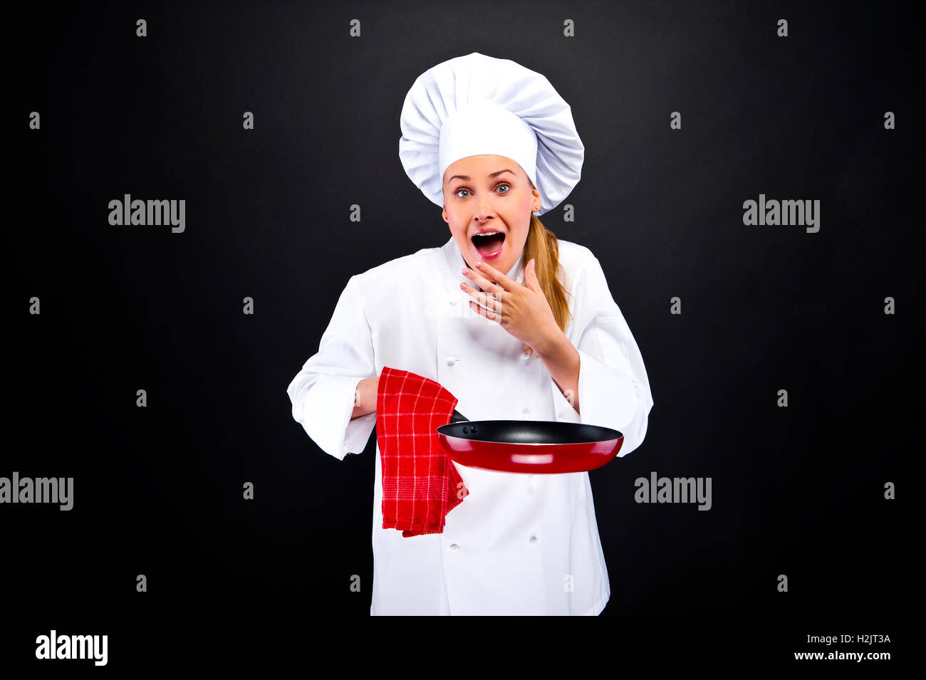 La cottura di cibo e di concetto - sorridente chef femmina su sfondo scuro in stato di shock Foto Stock