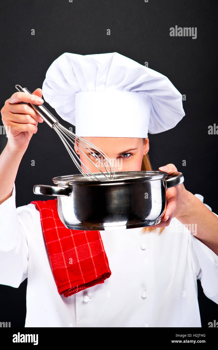 La cottura di cibo e di concetto - sorridente chef femmina con poy e cucchiaio cibo degustazione Foto Stock