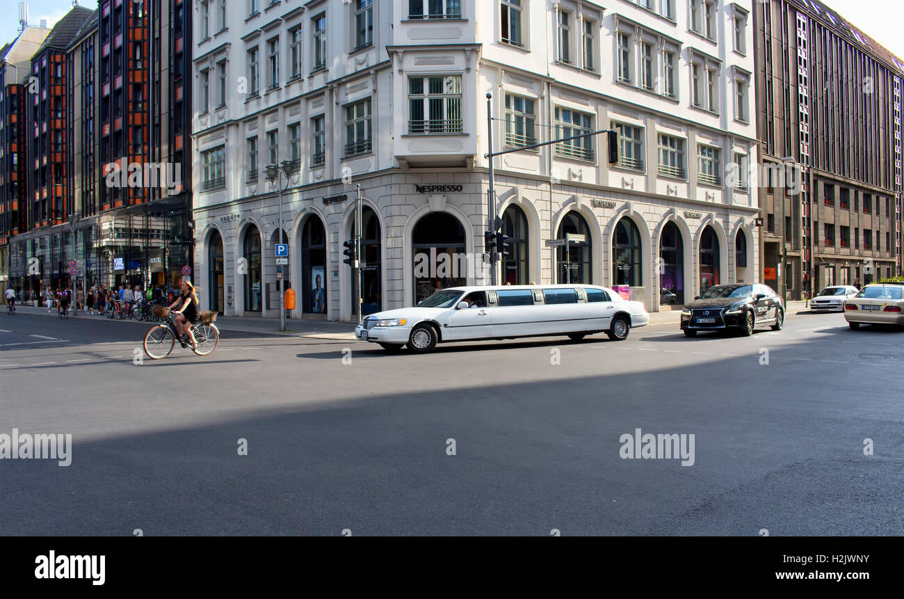 Auto di lusso in una delle principali strade dello shopping denominata "Friedrichstrase' alla sera Tempo in Berlino. Equitazione donna anche in bicicletta Foto Stock