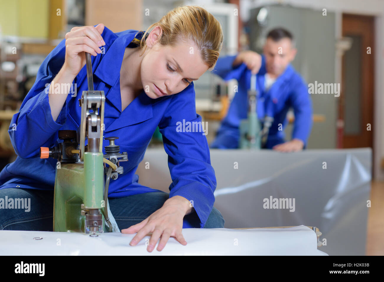 Uomo che fa buchi nella cintura di pelle con punzone e martello in  officina, primo piano Foto stock - Alamy