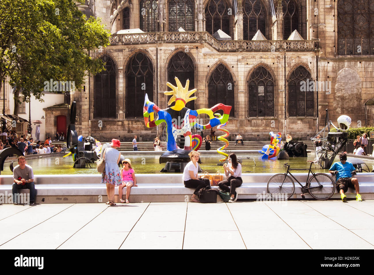 Persone sedersi intorno a Fontana Stravinsky e godere di giornata di sole a Parigi. Ci sono molte opere contemporanee in piscina. Foto Stock