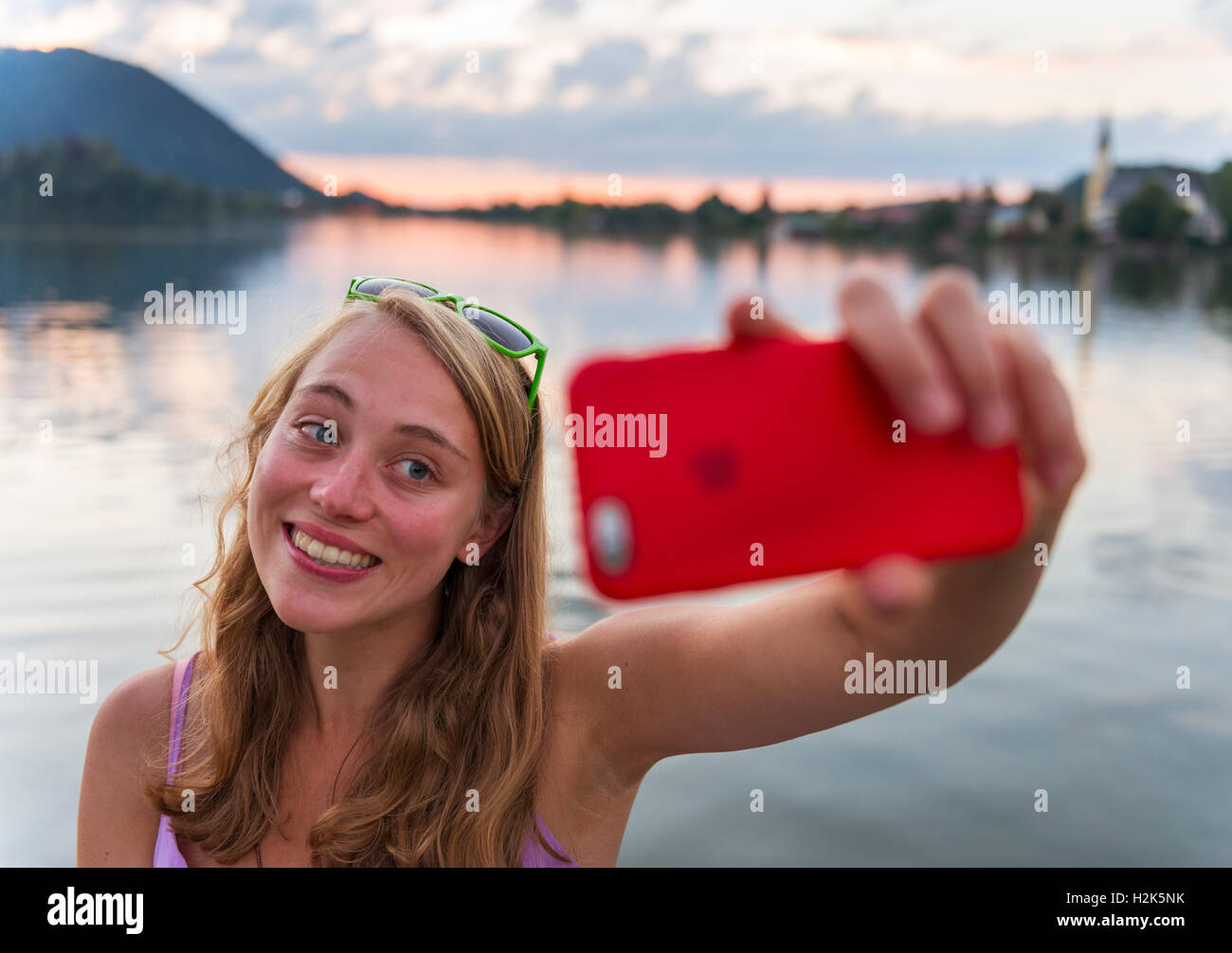 Giovane donna prendendo un selfie e sorridente, Schliersee, Alta Baviera, Baviera, Germania Foto Stock