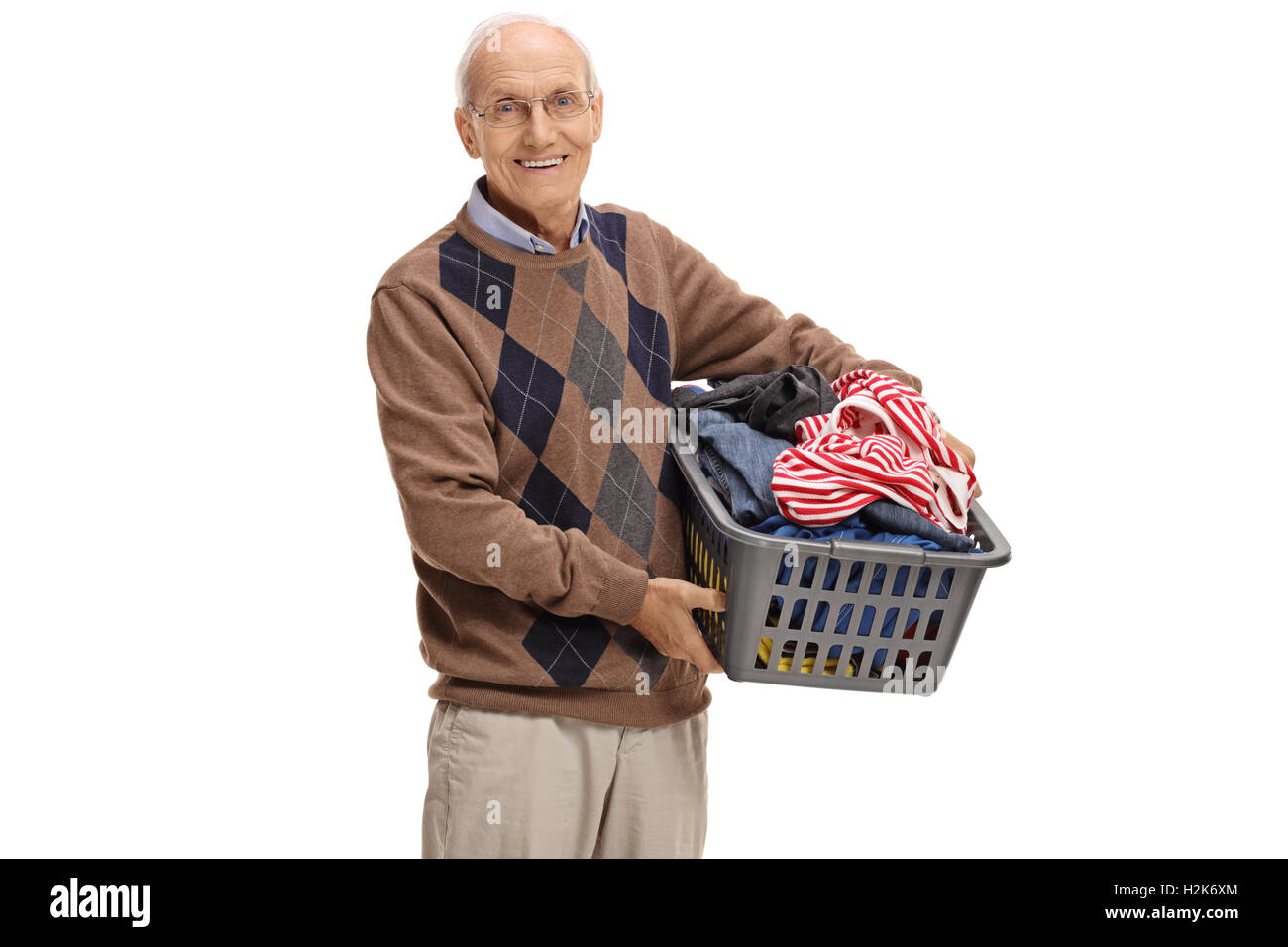 Uomo anziano tenendo un cesto per la biancheria pieno di vestiti isolati su sfondo bianco Foto Stock