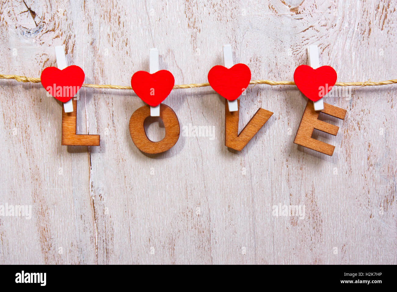 Lettere di legno e di cuore la formazione di parola amore su legno vecchio sfondo bianco Foto Stock