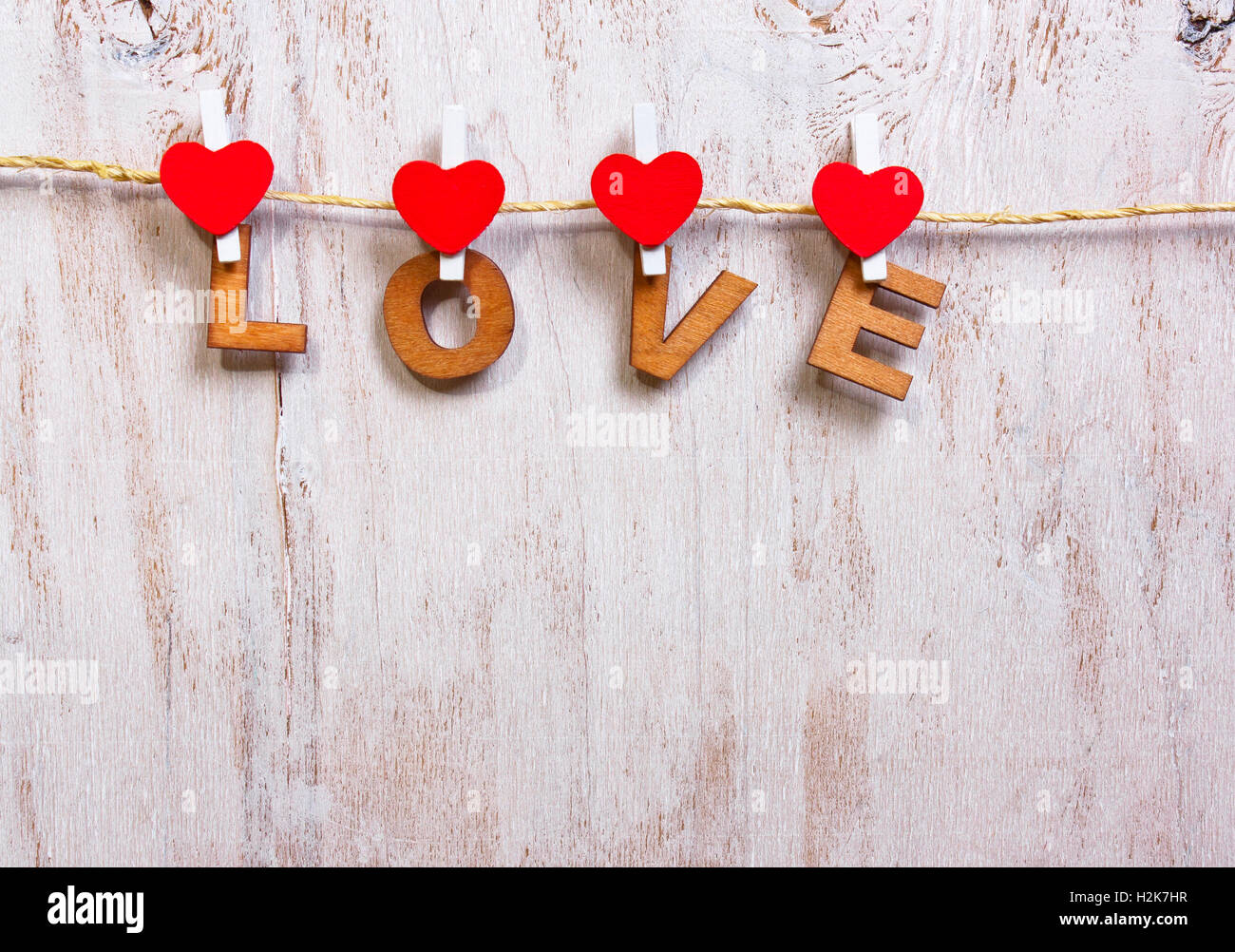 Lettere di legno e di cuore la formazione di parola amore su legno vecchio sfondo bianco Foto Stock