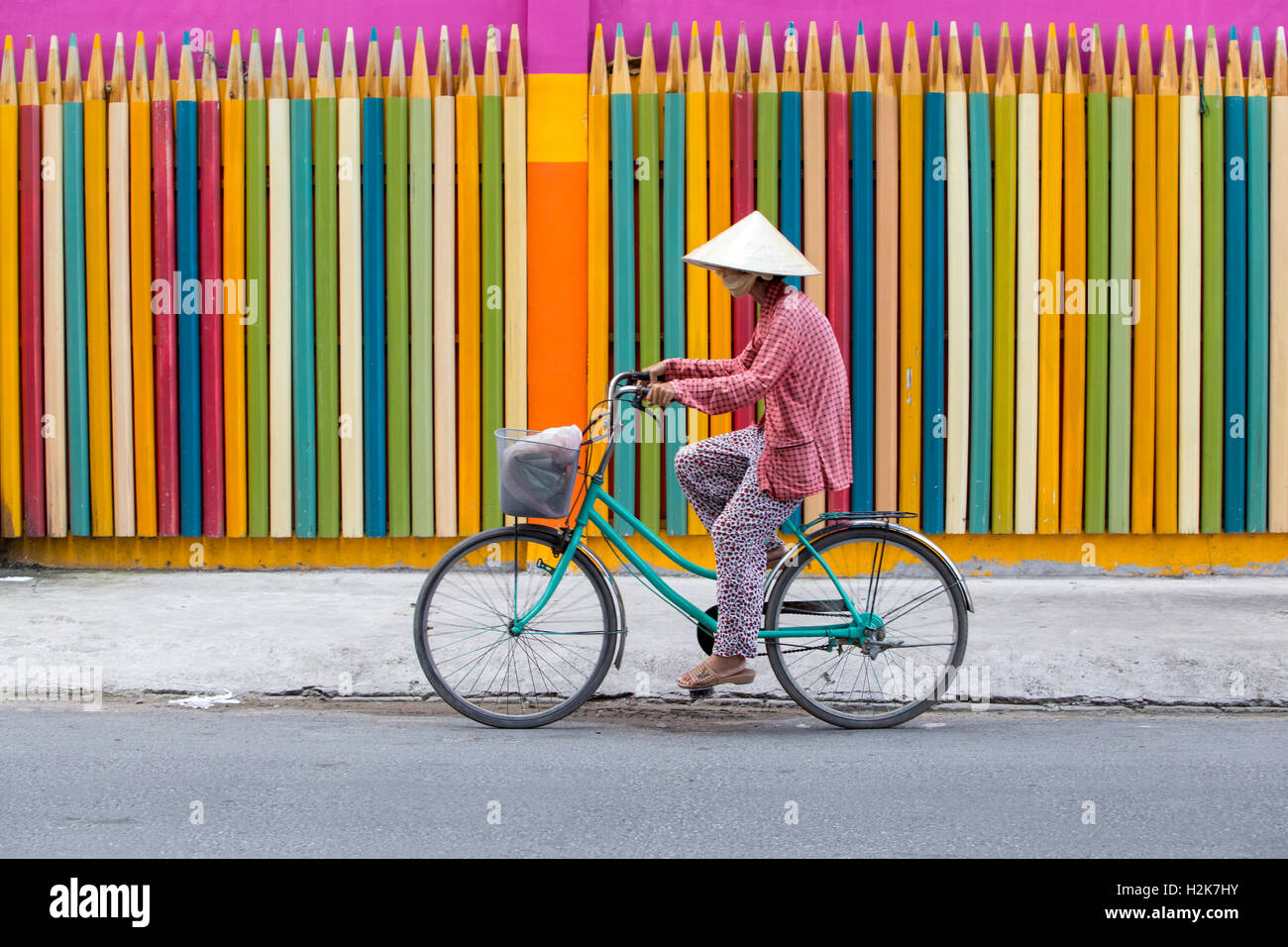 Il vietnamita donna con cappello conico, in bicicletta Foto Stock