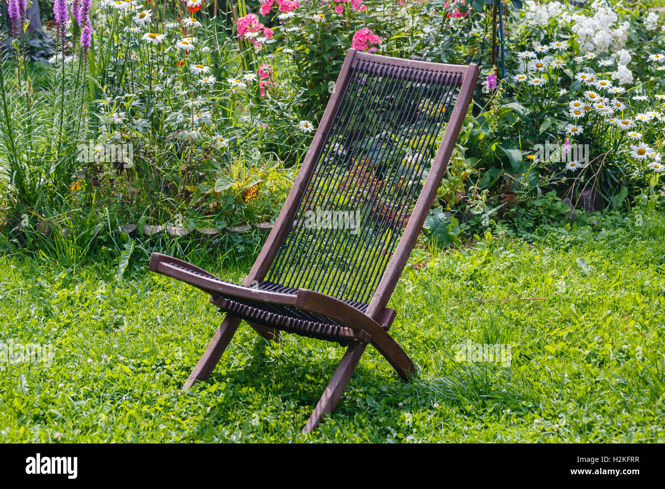 Sedia in legno da un set di mobili da giardino su un prato verde Foto Stock