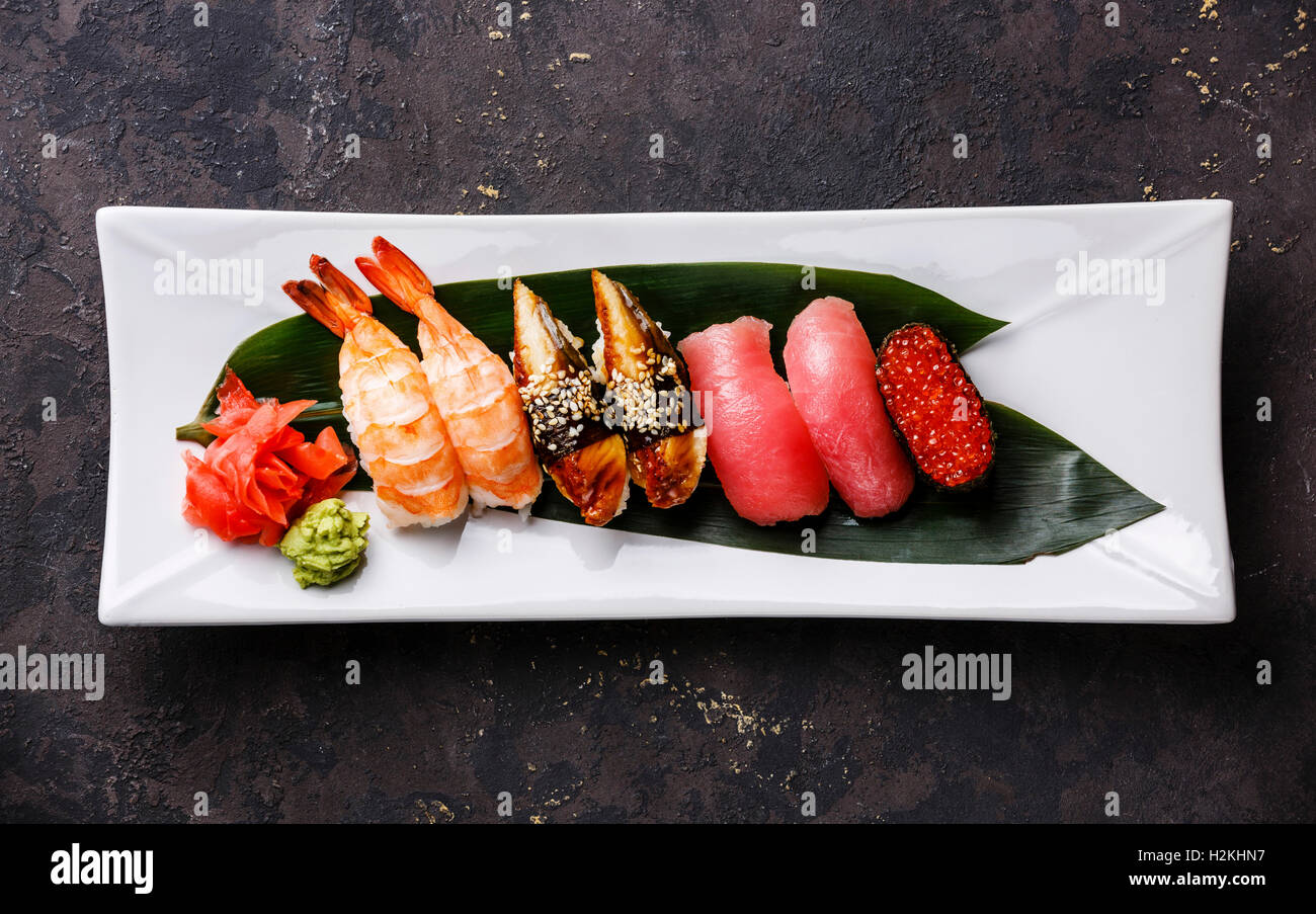E il nigiri sushi Gunkan impostato sulla piastra bianca su sfondo scuro Foto Stock