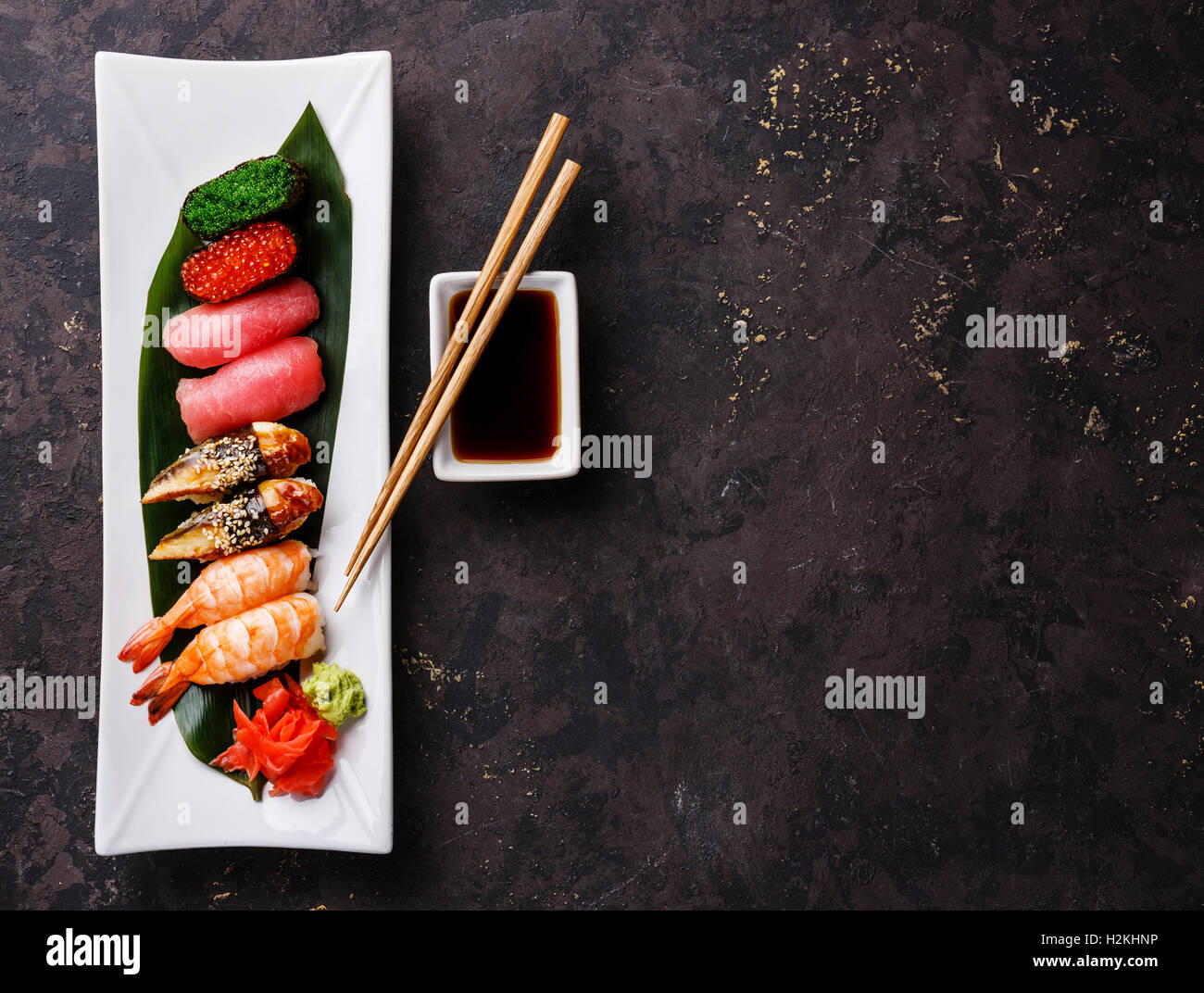 E il nigiri sushi Gunkan impostato sulla piastra bianca su sfondo scuro spazio copia Foto Stock