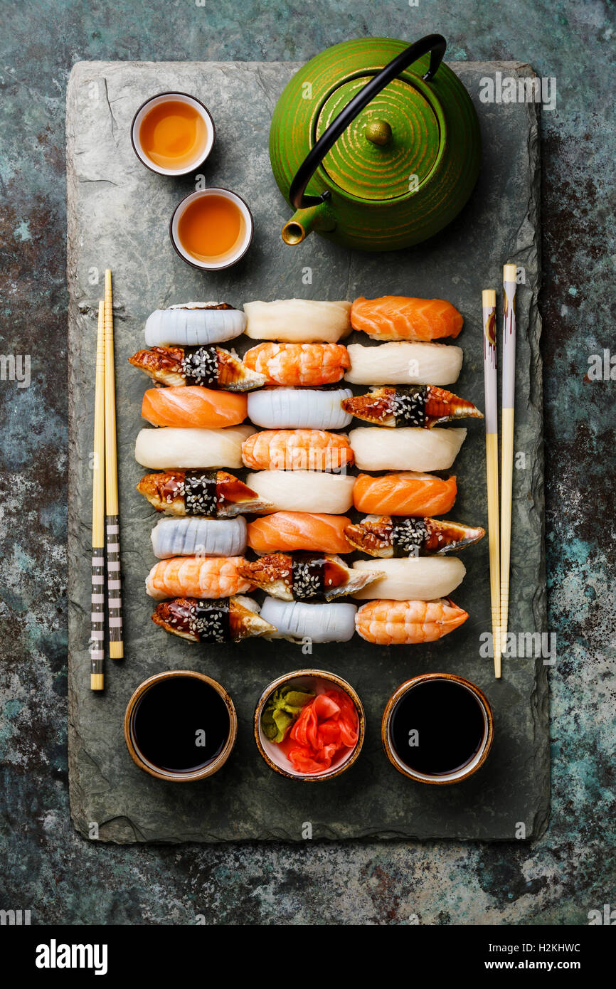 Il nigiri sushi set per due sulla pietra grigio ardesia scheda della piastra e il tè verde Foto Stock
