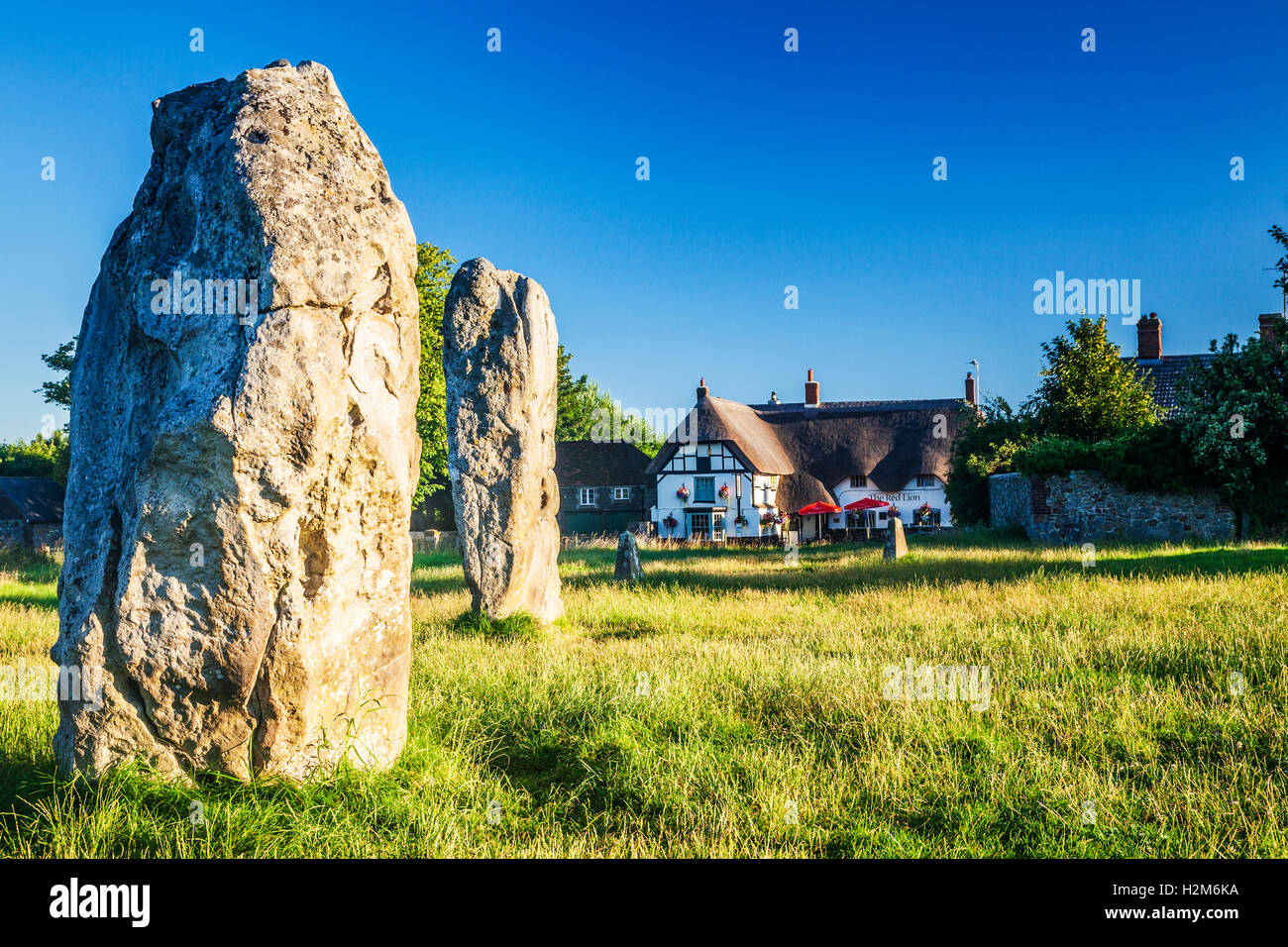 Sarsen le pietre e il Red Lion pub di Avebury, Wiltshire. Foto Stock