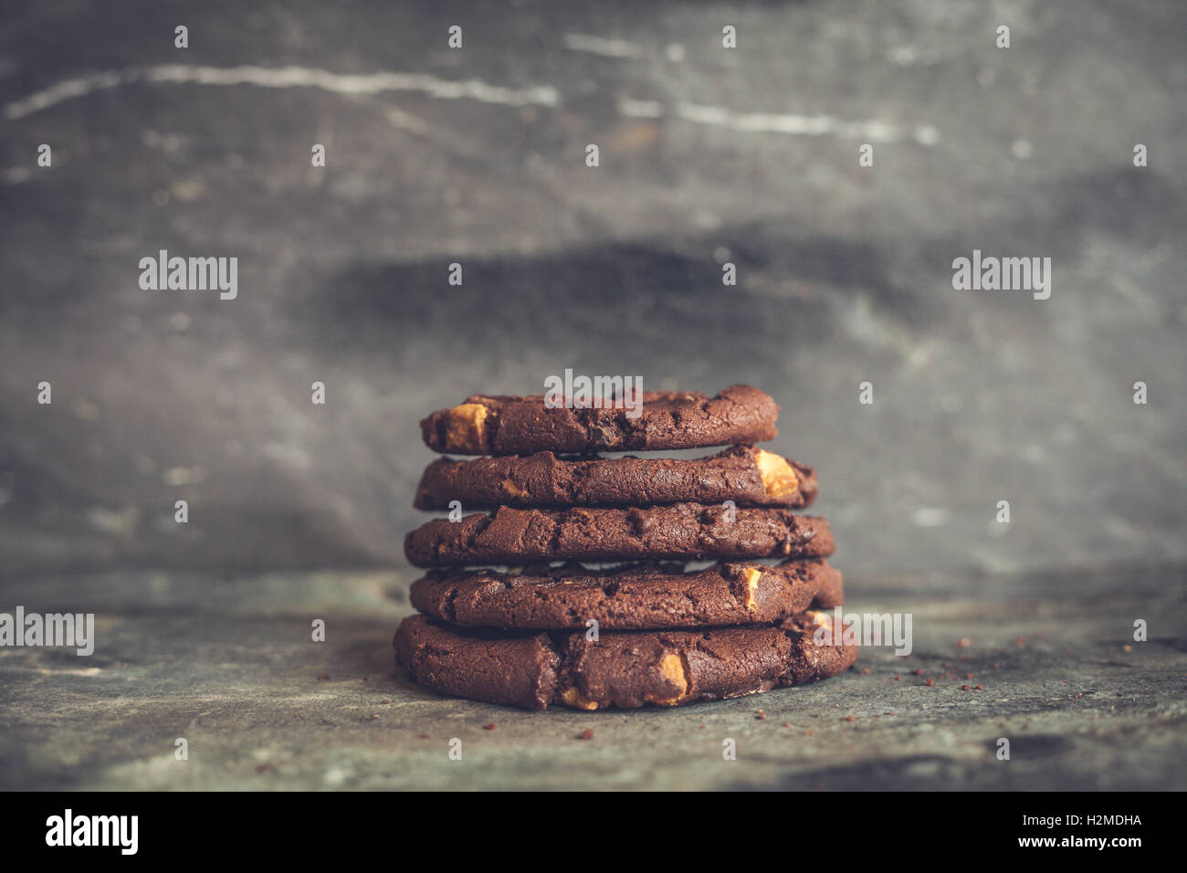Biscotti al cioccolato impilati su un sfondo di ardesia Foto Stock