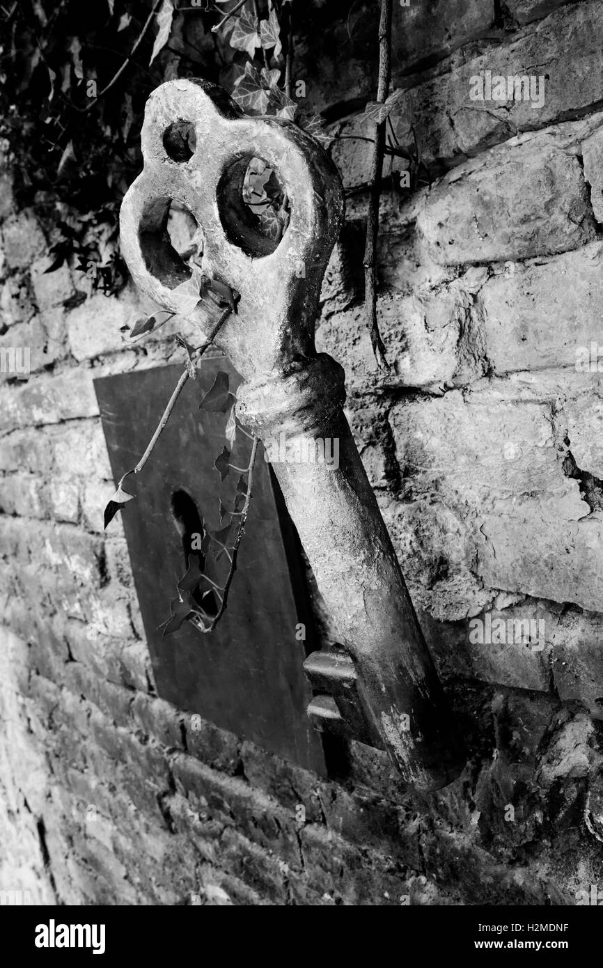 Vintage chiave gigante e toppa sul muro di mattoni Foto Stock