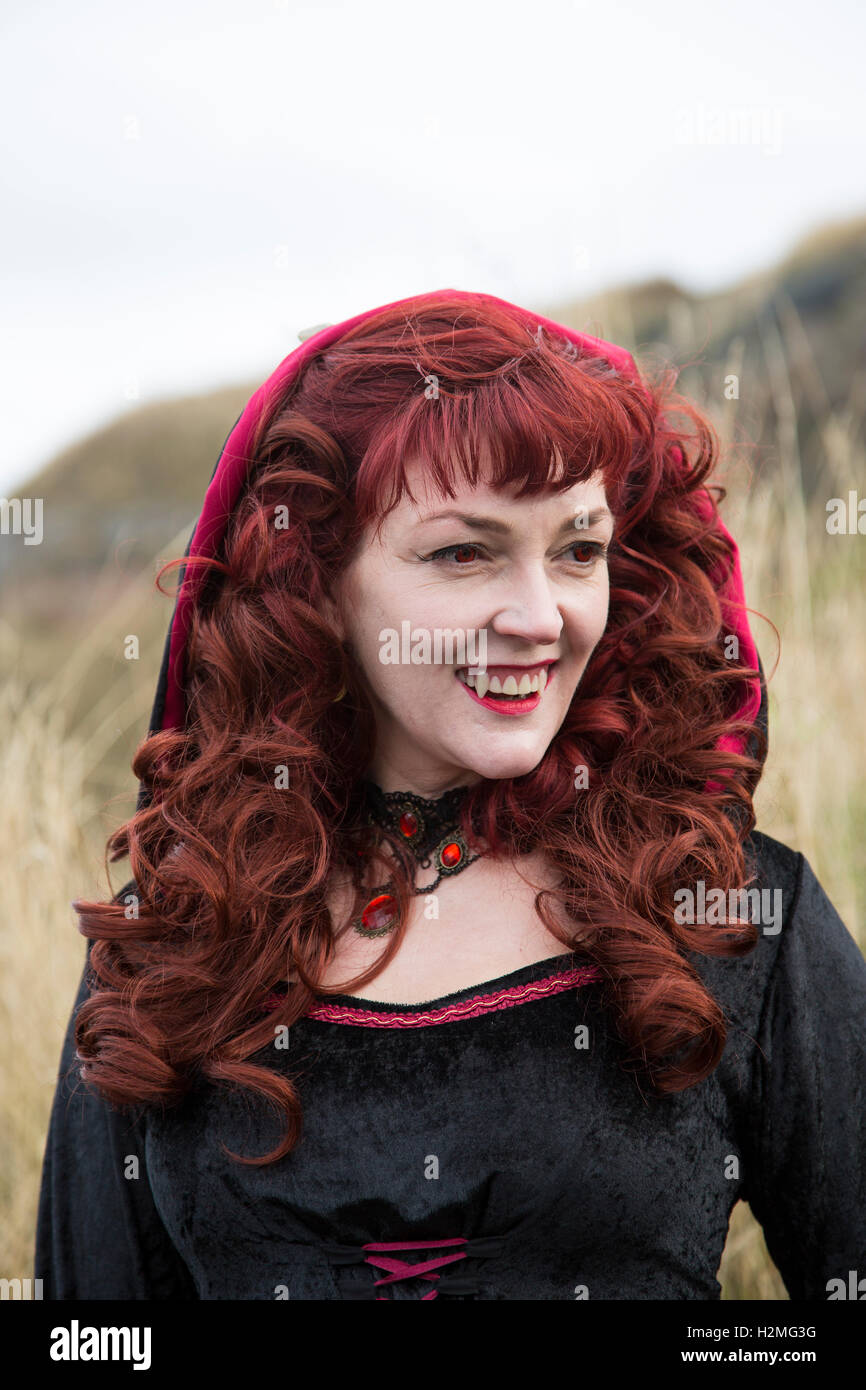 Goth donna abito nero con vampiro zanne Foto Stock