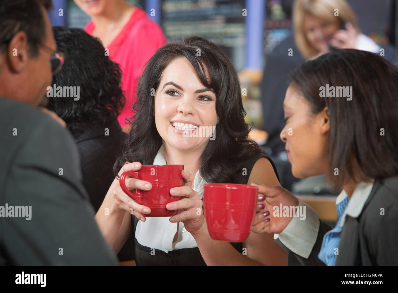 Grinning donna con caffè e collaboratori Foto Stock