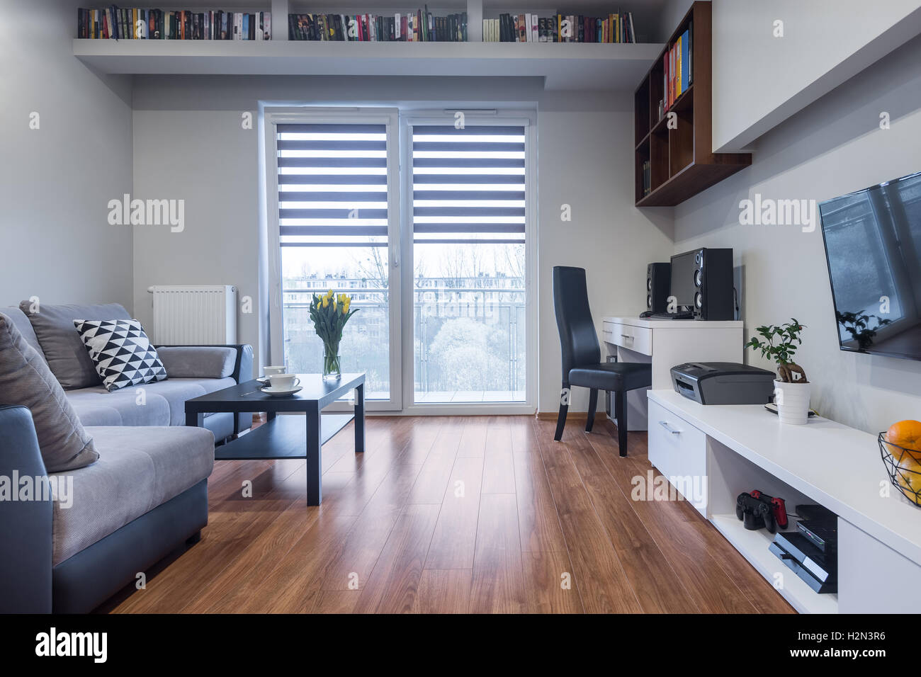 Nuovo design interno di casa con finestra, TV, ampio divano e mobili bianchi impostato Foto Stock
