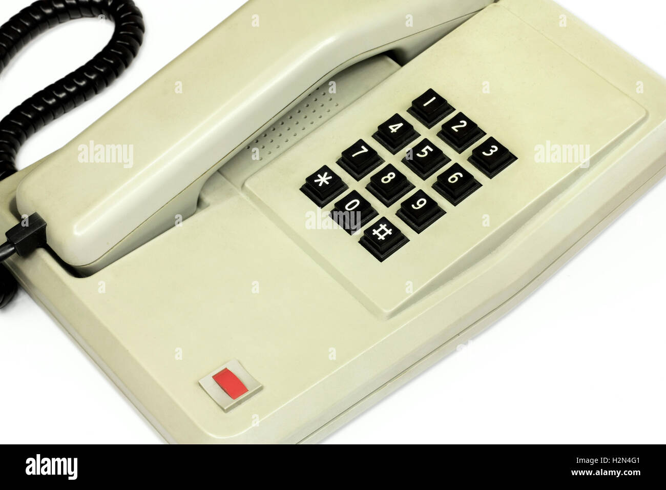 Il vecchio ufficio semplice telefono da tavolo e cavo isolato in prospettiva su sfondo bianco Foto Stock