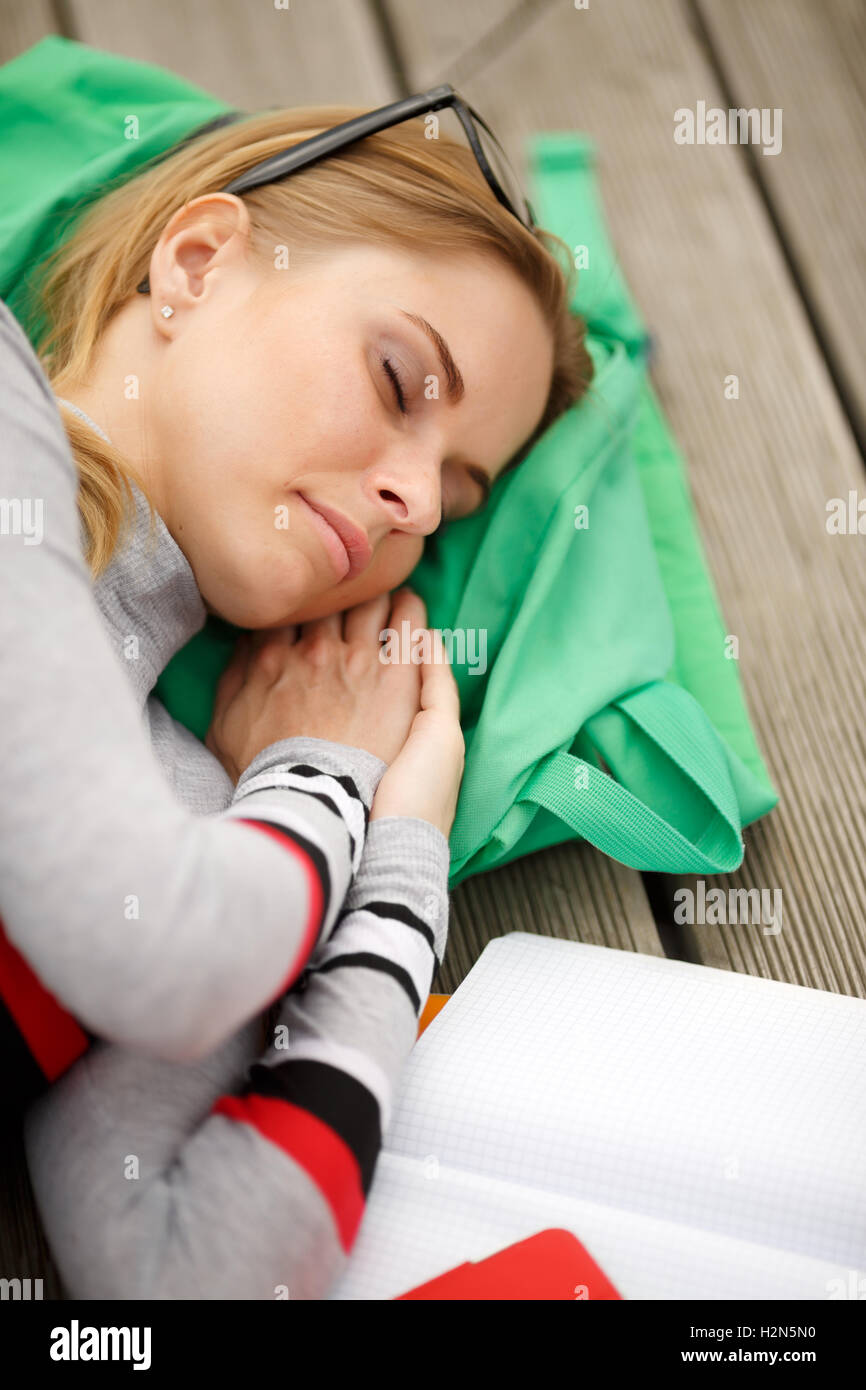 Ragazza dorme con libri all'aperto Foto Stock