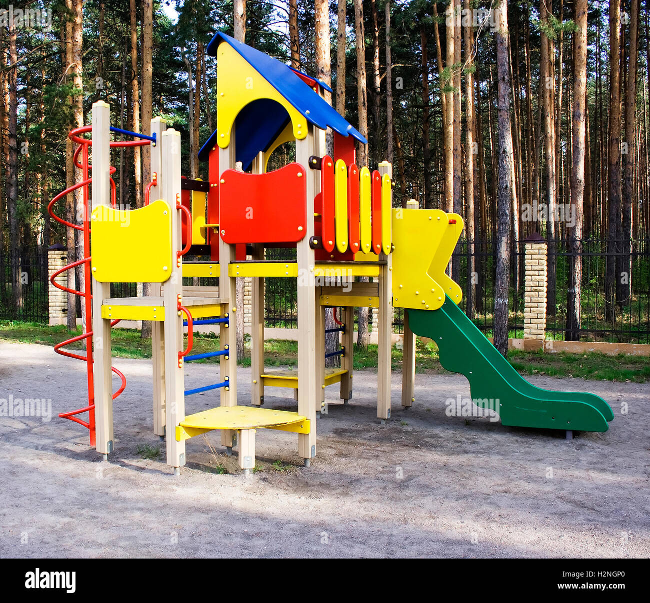Il parco giochi per i bambini o playset in un cortile della zona residenziale collocato in una pineta con alberi o a un parco. Foto Stock