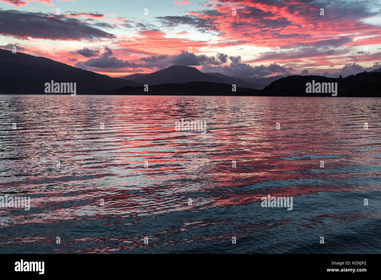 Tramonto sul Loch Lomond, con le colline ad ovest del loch stagliano Foto Stock